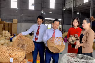 Bà Đặng Thị Dung (ngoài cùng bên phải) giới thiệu sản phẩm mây tre đan của doanh nghiệp với cán bộ Agribank.