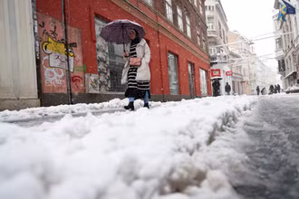 Một người phụ nữ đi trên phố trong cơn bão tuyết ở Sarajevo, Bosnia và Herzegovina. Ảnh: Reuters