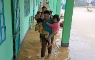 Các cô giáo điểm trường mần non bản Pắc Pạ đưa học sinh ra khỏi điểm trường do bị ngập.