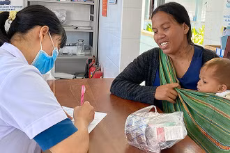 Cán bộ y tế khám, tư vấn sức khỏe cho bà mẹ và trẻ em vùng cao.