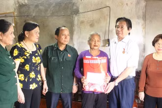Các thành viên đoàn công tác trao tặng quà cho cựu thanh niên xung phong Nguyễn Thị Bình.