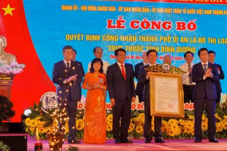 Thừa ủy nhiệm Thủ tướng Chính phủ, Thứ trưởng Xây dựng Nguyễn Tường Văn (phải) trao Quyết định công nhận thành phố Dĩ An là đô thị loại II cho lãnh đạo thành phố Dĩ An. 