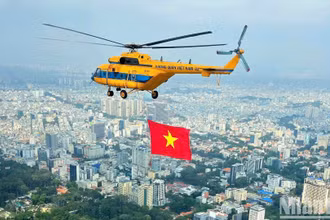 Máy bay trực thăng kéo cờ Tổ quốc luyện tập trên bầu trời Thành phố Hồ Chí Minh.