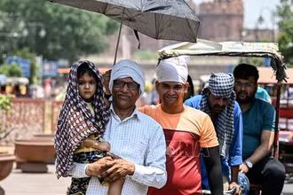 Người dân che ô tránh nắng nóng tại New Delhi, Ấn Độ, ngày 21/5/2024. (Ảnh: AFP/TTXVN)