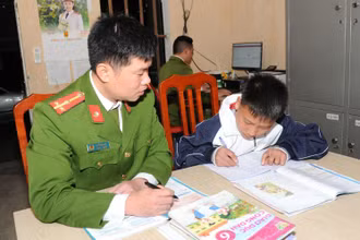 Thượng úy La Tuấn Anh, Công an xã Niêm Sơn, huyện Mèo Vạc tranh thủ dạy cháu Ly Mí Hồng học bài.