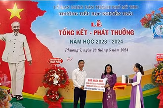 Phó Giám đốc Sở Giáo dục và Đào tạo tỉnh Tiền Giang Huỳnh Thị Phượng nhận bảng tượng trưng 600 phụ san tranh panorama "Chiến dịch Điện Biên Phủ" của Báo Nhân Dân.
