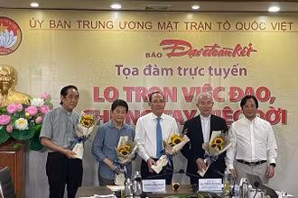 Tổng Biên tập Báo Đại Đoàn Kết Lê Anh Đạt tặng hoa các đại biểu dự Tọa đàm.