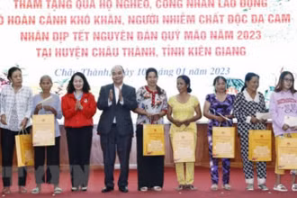 Chủ tịch nước Nguyễn Xuân Phúc tặng quà cho hộ nghèo, công nhân lao động có hoàn cảnh khó khăn, người nhiễm chất độc da cam trên địa bàn. (Ảnh: Thống Nhất/TTXVN)