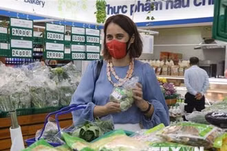 Đại sứ New Zealand tại Việt Nam Tredene Dobson mua rau an toàn tại siêu thị Co.op Mart Quy Nhơn do nông dân Bình Định sản xuất từ dự án Rau an toàn Bình Định. (Ảnh: Kha Phạm/TTXVN)