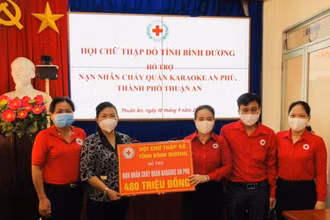 Chủ tịch Hội Chữ thập đỏ tỉnh Bình Dương Nguyễn Thị Lệ Trinh (thứ ba từ phải sang) trao tiền hỗ trợ nạn nhân vụ cháy cho lãnh đạo Ủy ban nhân dân thành phố Thuận An.