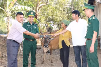 Thượng tá Rơ Lan Ngân, Phó Chính ủy Bộ đội Biên phòng tỉnh Đắk Lắk cùng đại diện các đơn vị trao tặng bò sinh sản cho bà H’Nhem Ê Ban tại xã biên giới Krông Na, huyện Buôn Đôn.