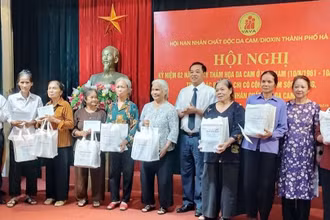 Phó Giám đốc Sở Lao động, Thương binh và Xã hội Hà Nội trao tặng các phần quà động viên những người mẹ, người vợ có công chăm sóc, nuôi dưỡng nạn nhân chất độc da cam.
