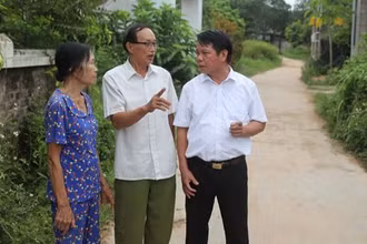 Ông Ma Hữu Khang (giữa) trao đổi về công tác vận động nhân dân hiến đất làm đường.