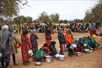 Trẻ em xếp hàng chờ nhận thức ăn cứu trợ tại trại tị nạn ở Aleppo, Syria. (Ảnh tư liệu: AFP/TTXVN)