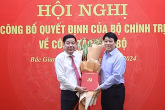 Đồng chí Lương Cường, Ủy viên Bộ Chính trị, Thường trực Ban Bí thư trao quyết định và tặng hoa chúc mừng đồng chí Nguyễn Văn Gấu nhận trọng trách mới. 