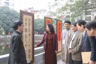 Các đại biểu tham quan triển lãm thư pháp bên hồ Văn.