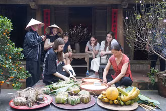 Các vị khách quốc tế trải nghiệm gói bánh chưng.
