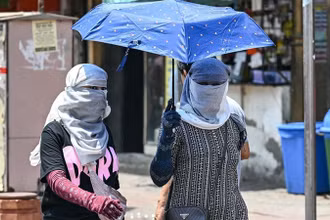 Người dân di chuyển dưới trời nắng nóng tại New Delhi, Ấn Độ. (Ảnh: AFP/TTXVN)