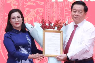 Trưởng Ban Tuyên giáo Trung ương Nguyễn Trọng Nghĩa trao Quyết định cho đồng chí Đinh Thị Mai. (Ảnh: TTXVN)