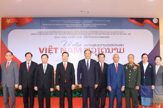 Đồng chí Võ Văn Thưởng (thứ 4 từ trái qua phải), đồng chí Sonsay Siphandone (thứ 5 từ trái qua phải) tại lễ khai mạc triển lãm, chiều 18/7. (Ảnh: XUÂN SƠN)