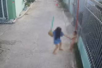 Bà Trang dùng chổi đánh cháu T. (Ảnh cắt từ camera)