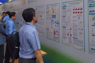 Các đại biểu tìm hiểu các báo cáo bằng poster trưng bày tại hội nghị.