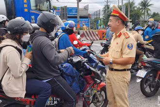Trạm Cảnh sát giao thông Tân Túc phát tờ rơi tuyên truyền và tổ chức tặng nước suối, khăn lạnh cho người dân về quê nghỉ lễ.