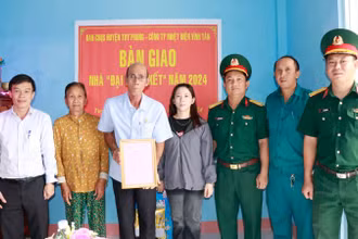 Đại diện Công ty Nhiệt điện Vĩnh Tân và Ban Chỉ huy Quân sự huyện Tuy Phong bàn giao nhà cho gia đình ông Hồ Thái.