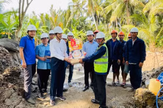 Thành viên Hội đồng thành viên EVNSPC Lê Xuân Hải (áo trắng) tặng quà động viên lực lượng lao động thi công dự án trên địa bàn tỉnh Bến Tre ngày 26 Tết.