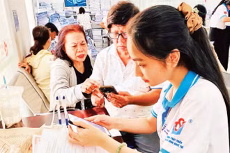 Tình nguyện viên Trung tâm Phát triển khoa học và công nghệ trẻ (Thành đoàn TP Hồ Chí Minh) hỗ trợ người dân làm các thủ tục hành chính.