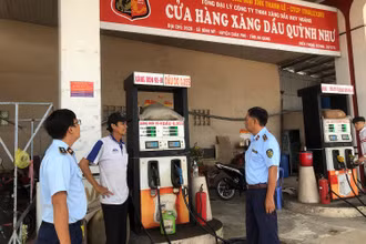 Lực lượng chức năng kiểm tra một cửa hàng xăng dầu tại tỉnh An Giang. 