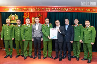 Tổng Biên tập Báo Nhân Dân Lê Quốc Minh (thứ 4 từ phải sang) và các đồng chí trong đoàn công tác trao tặng Báo Nhân Dân Xuân Quý Mão 2023 đến các cán bộ, chiến sĩ Cục Cảnh sát điều tra tội phạm về tham nhũng, kinh tế, buôn lậu. (Ảnh: THÀNH ĐẠT)