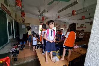 Nước tràn vào lớp tại trường Tiểu học Phú Lương 2 (quận Hà Đông) khiến cho học sinh phải đứng cả lên bàn để tránh. (Ảnh: CTV)