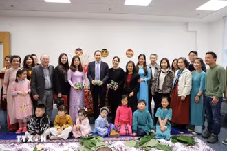 Ông Đỗ Minh Hùng, Đại sứ Việt Nam tại Anh (đứng giữa), cùng với Ban tổ chức và các đội tham gia hội thi gói bánh chưng. (Ảnh: TTXVN)