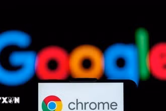 Biểu tượng Chrome trên màn hình điện thoại và biểu tượng Google (phía sau). (Ảnh: Getty Images/TTXVN)