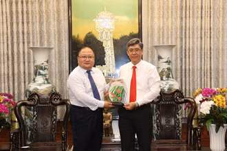 Phó Chủ tịch UBND tỉnh Bình Thuận Nguyễn Minh tặng quà lưu niệm là hình ảnh biểu tượng thanh long Bình Thuận cho Đoàn đại biểu Nhà xuất bản Nhân dân Giang Tô.