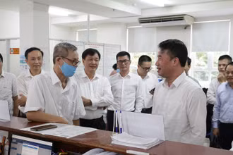 Tổng Giám đốc Bảo hiểm xã hội Việt Nam Nguyễn Thế Mạnh trao đổi với người dân đến làm việc qua tính năng đặt lịch làm việc trực tuyến tại bộ phận “một cửa” Bảo hiểm xã hội Thành phố Hồ Chí Minh.