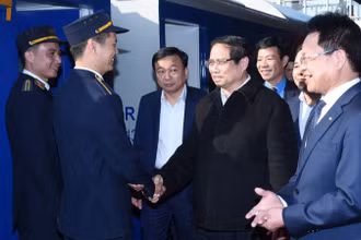 Thủ tướng Phạm Minh Chính hỏi thăm nhân viên ngành đường sắt Việt Nam phục vụ trên "Chuyến tàu Xuân" xuất phát tại ga Hà Nội. (Ảnh: TRẦN HẢI)