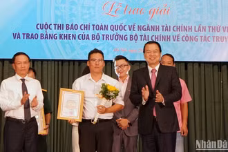 Thứ trưởng Tài chính Nguyễn Đức Chi và Phó Chủ tịch Thường trực Hội Nhà báo Việt Nam Nguyễn Đức Lợi trao giải A cho đại diện nhóm tác giả của Báo Nhân Dân. (Ảnh: TRUNG HƯNG)