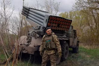 Binh sĩ Ukraine đứng cạnh hệ thống rocket phóng loạt ở Kharkov. (Ảnh: Reuters)