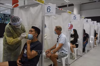 Nhân viên y tế lấy mẫu xét nghiệm Covid-19 cho người dân tại Singapore. (Ảnh tư liệu: THX/TTXVN)