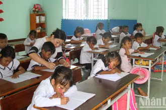 Giáo viên Trường Tiểu học Phước Thắng, huyện Bác Ái, tỉnh Ninh Thuận hướng dẫn học sinh lớp 1 tập viết. (Ảnh minh họa: NGUYỄN TRUNG) 