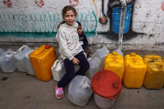 Trẻ em Palestine chờ lấy nước bên trong một trại di tản ở Gaza, ngày 6/4/2025. (Ảnh: Xinhua) 