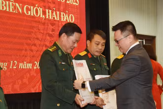 Tổng Biên tập Báo Nhân Dân Lê Quốc Minh trao tặng báo Xuân cho đại diện các đơn vị nhận báo. (Ảnh: TRẦN HẢI)
