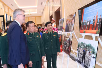 Thượng tướng Hoàng Xuân Chiến, Thứ trưởng Quốc phòng và Phó Tổng Thư ký Liên hợp quốc Jean-Pierre Lacroix cùng các đại biểu xem triển lãm ảnh về phụ nữ với hoạt động gìn giữ hòa bình Liên hợp quốc.
