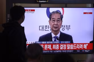 Người dân theo dõi bài phát biểu của ông Han Duck Soo tại ga tàu Seoul, ngày 1/5/2025. (Ảnh: Xinhua)