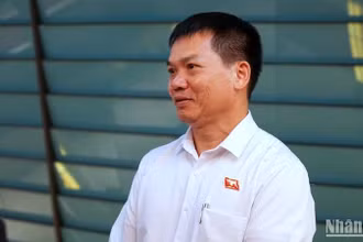Đại biểu Dương Khắc Mai (Đoàn đại biểu Quốc hội tỉnh Đắc Nông) trao đổi bên hành lang Quốc hội. (Ảnh: TRUNG HƯNG)