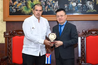 Tổng Biên tập Báo Nhân Dân Lê Quốc Minh tặng quà lưu niệm Chủ tịch hãng Thông tấn Prensa Latina Luis Enrique González Acosta. (Ảnh: DUY LINH)