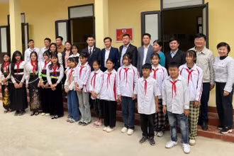 Các đại biểu cùng giáo viên và các em học sinh Trường Tiểu học-Trung học cơ sở Đá Đỏ trước khu nhà bán trú mới hoàn thành. (Ảnh: Đại sứ quán Nhật Bản tại Việt Nam) 