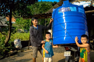 Người dân Yên Bái bị ảnh hưởng bởi bão lũ nhận thùng nước hỗ trợ từ UNICEF. (Ảnh: UNICEF Việt Nam) 